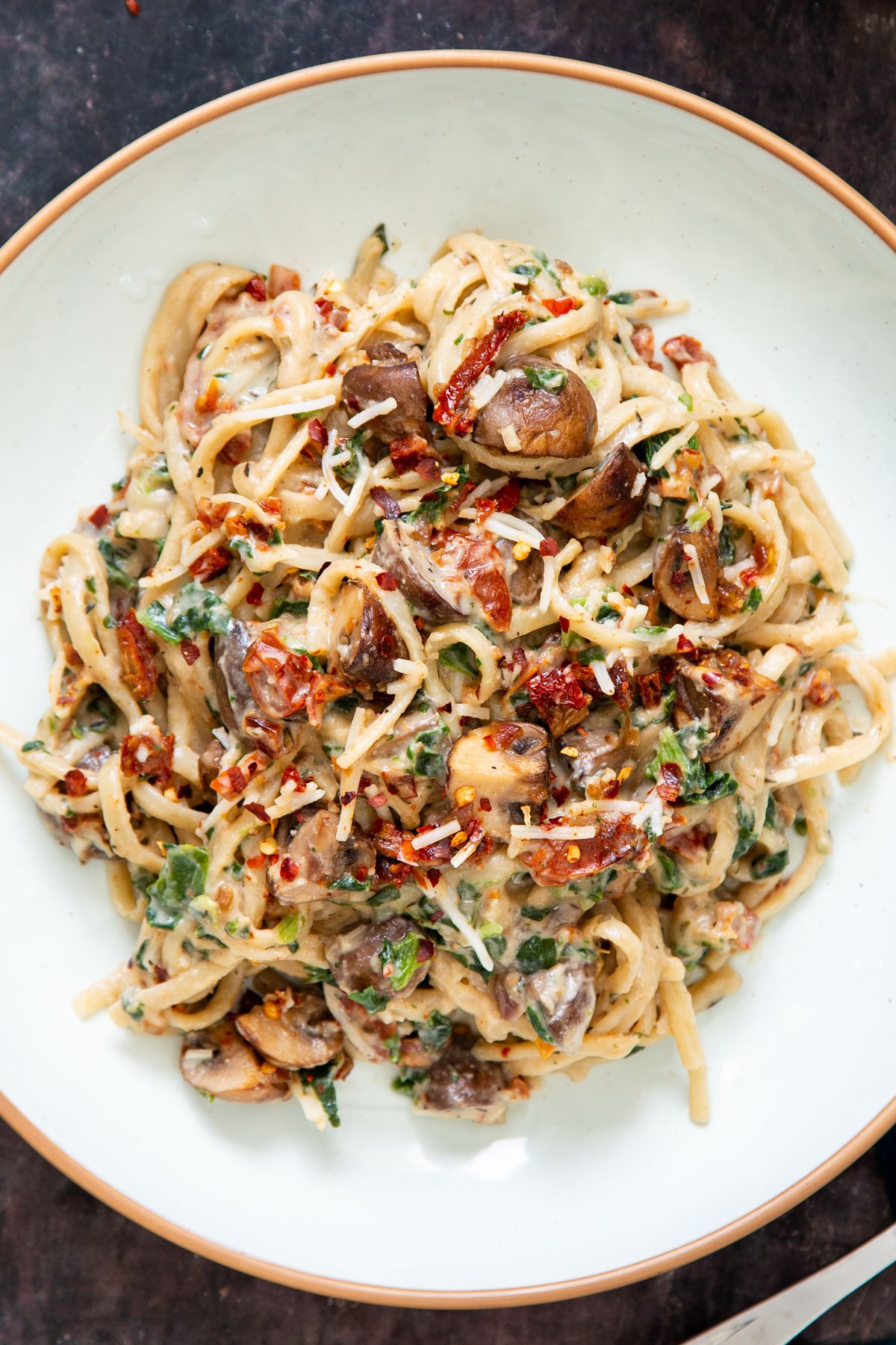 a plate of one pot vegan creamy mushroom pasta with spinach and sundried tomatoes