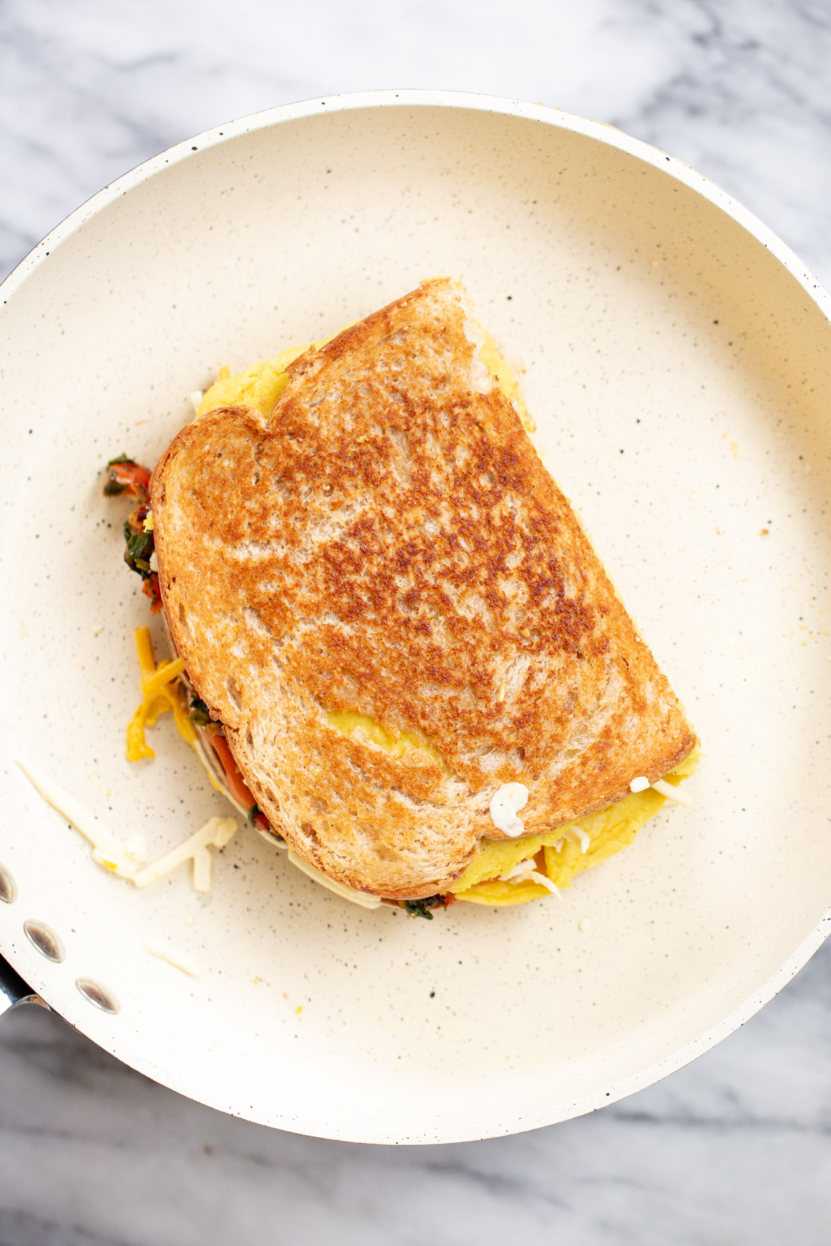 freshly cooked vegan fold over egg sandwich in white pan
