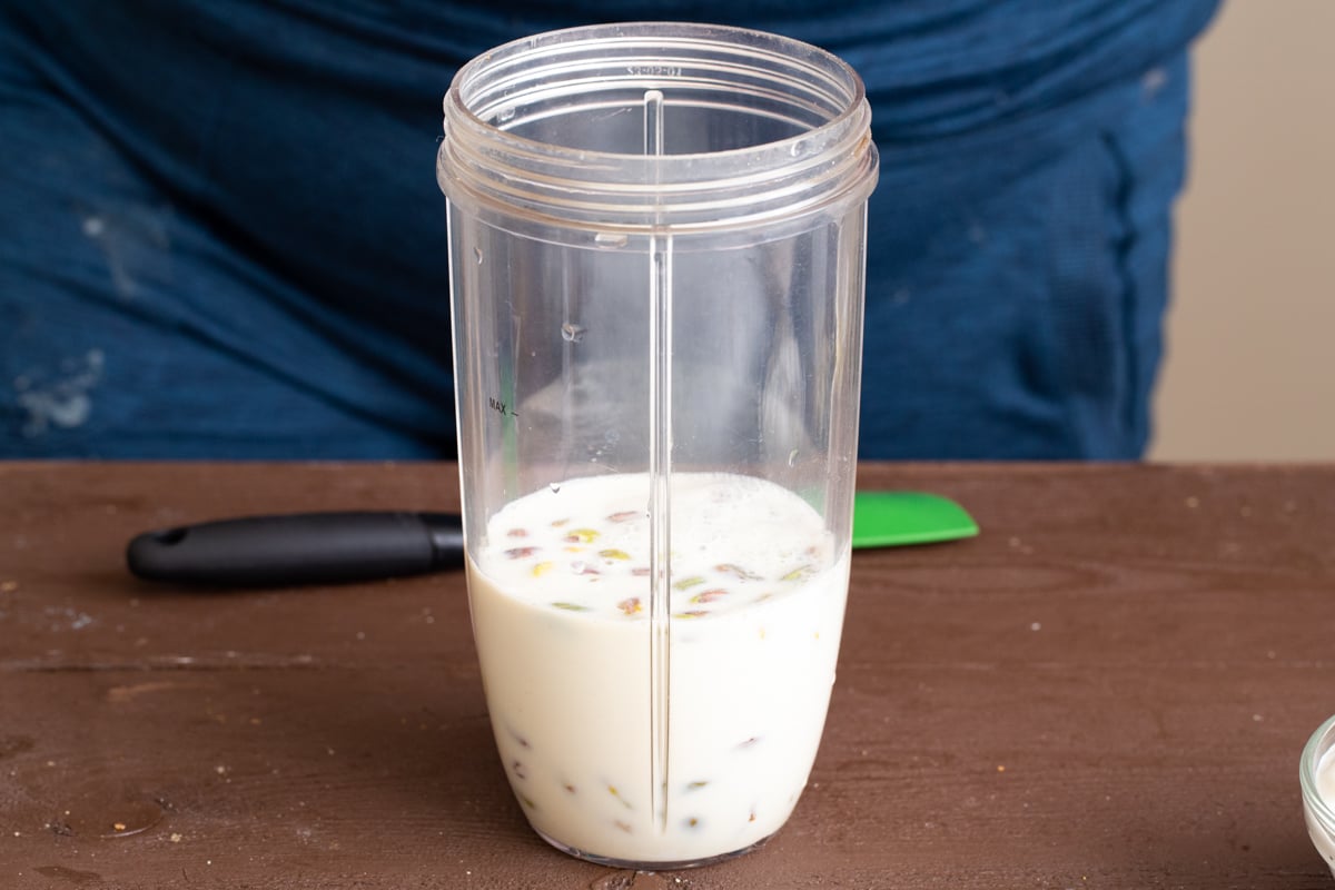 plant-based milk and pistachios in a nutribullet container