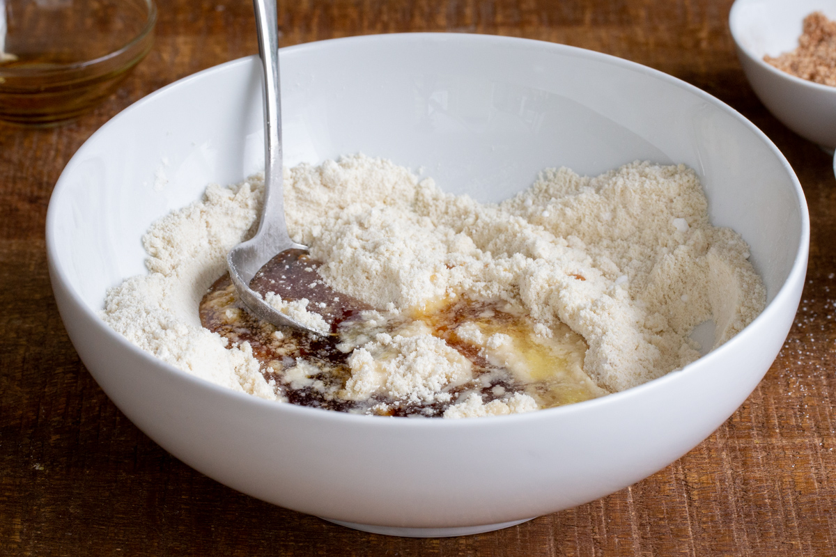 almond flour cookie dough being mixed in a white bowl
