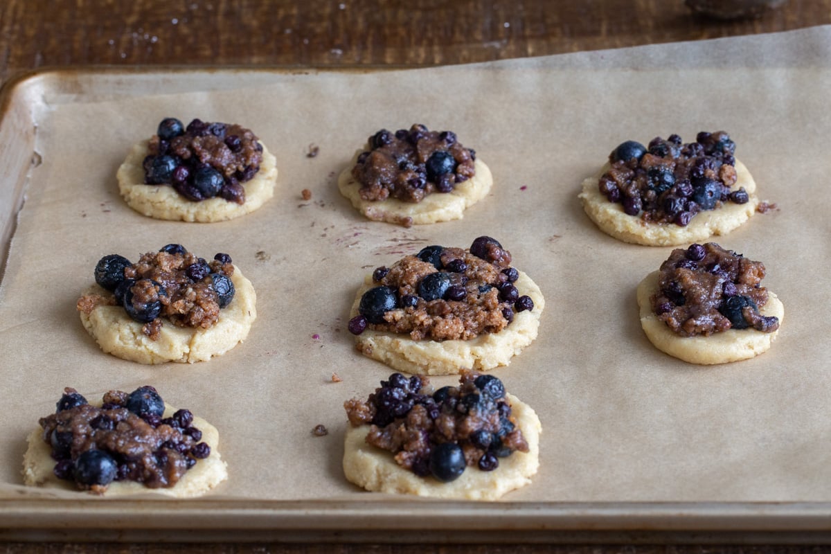 vegan blueberry muffin cookies on a lined baking sheet