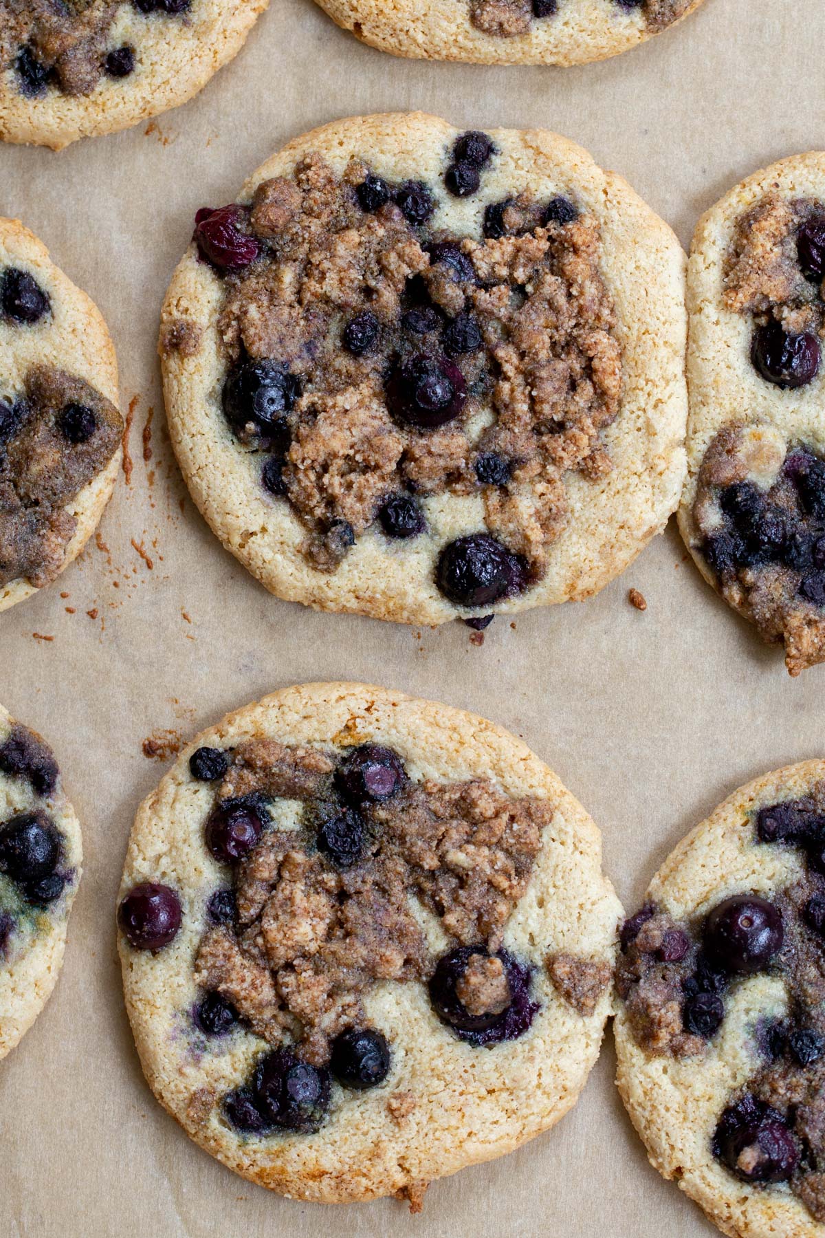overhead shot of blueberry muffin cookies on a lined baking sheet