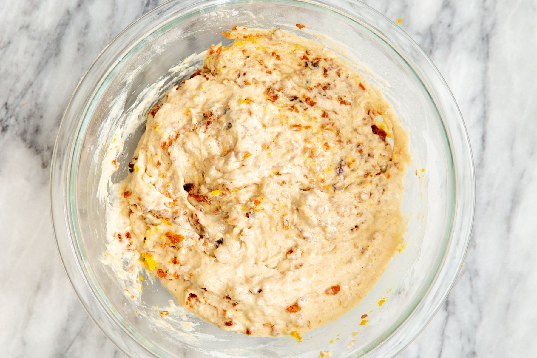carrot cake batter studded with dates in a glass bowl