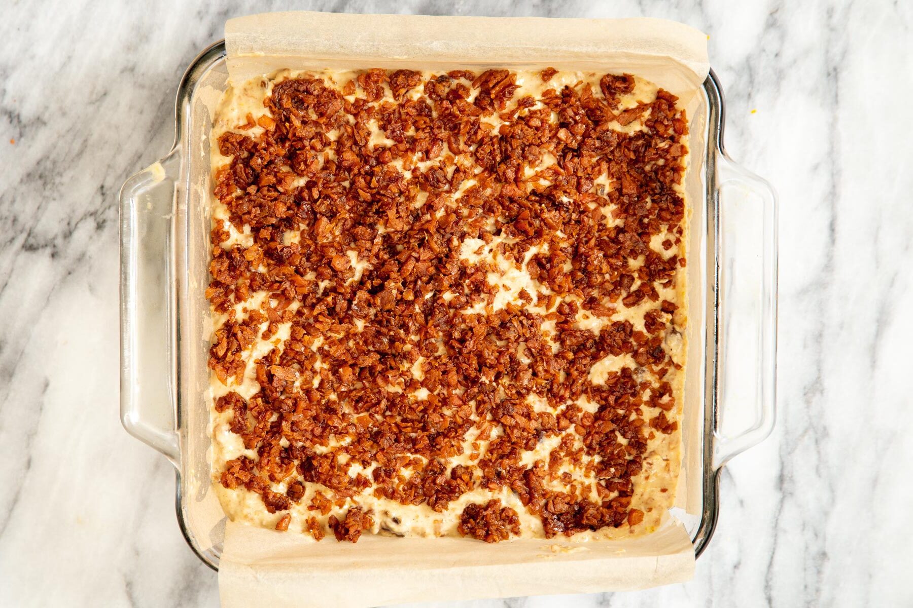 vegan carrot cake bars being topped with cinnamon brown sugar streusel before baking