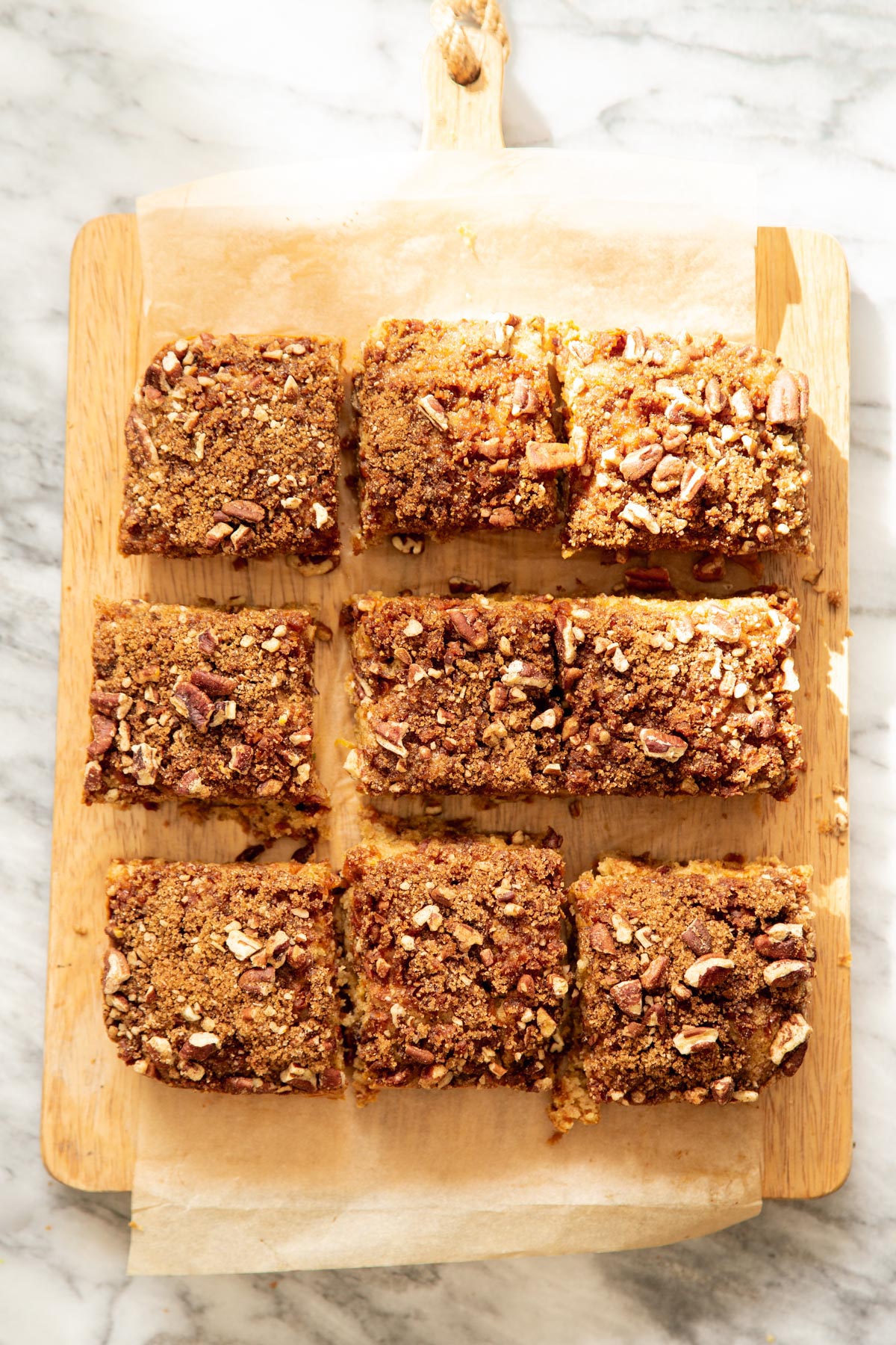 overhead shot of vegan carrot cake bars on a piece of parchment paper