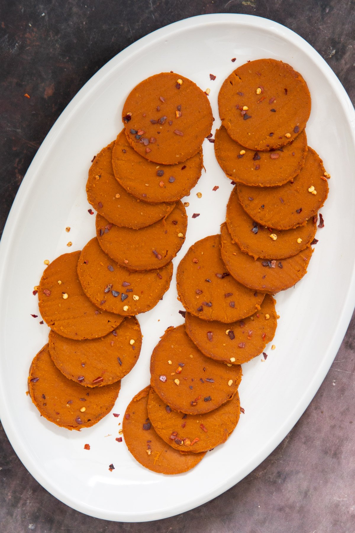 vegan pepperoni sliced and plated in an oval plate