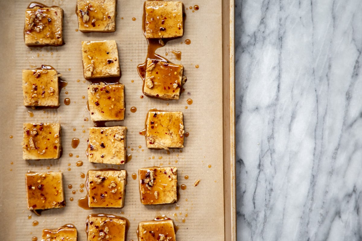 marinated tofu cubes on a sheetpan ready for baking