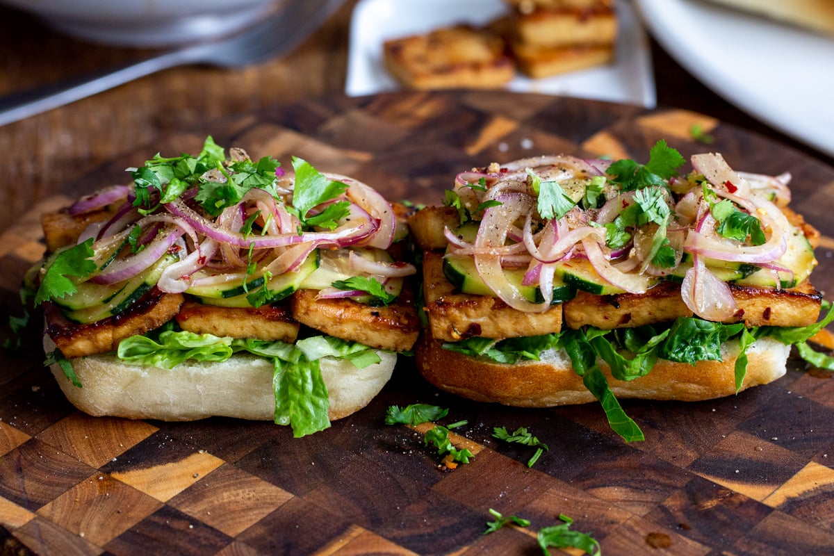 assembled chili garlic tofu sandwiches on a chopping board