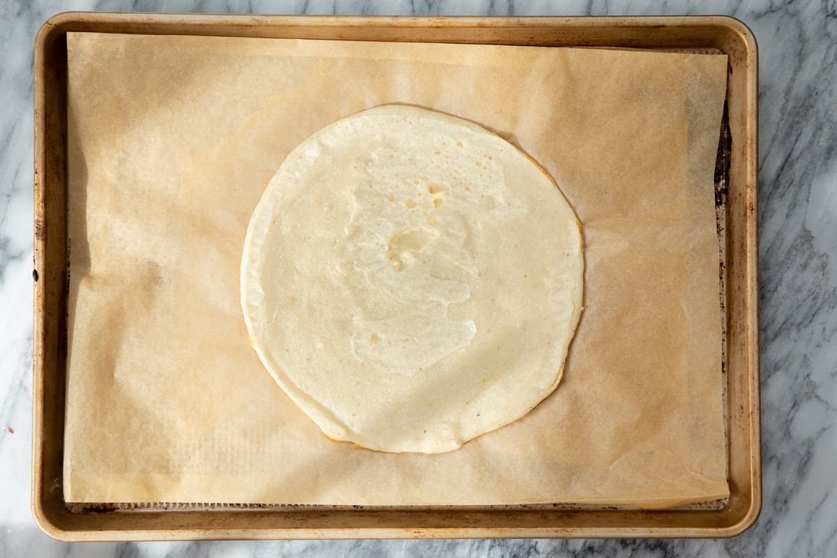 almond flour pizza crust on a sheet of parchment paper