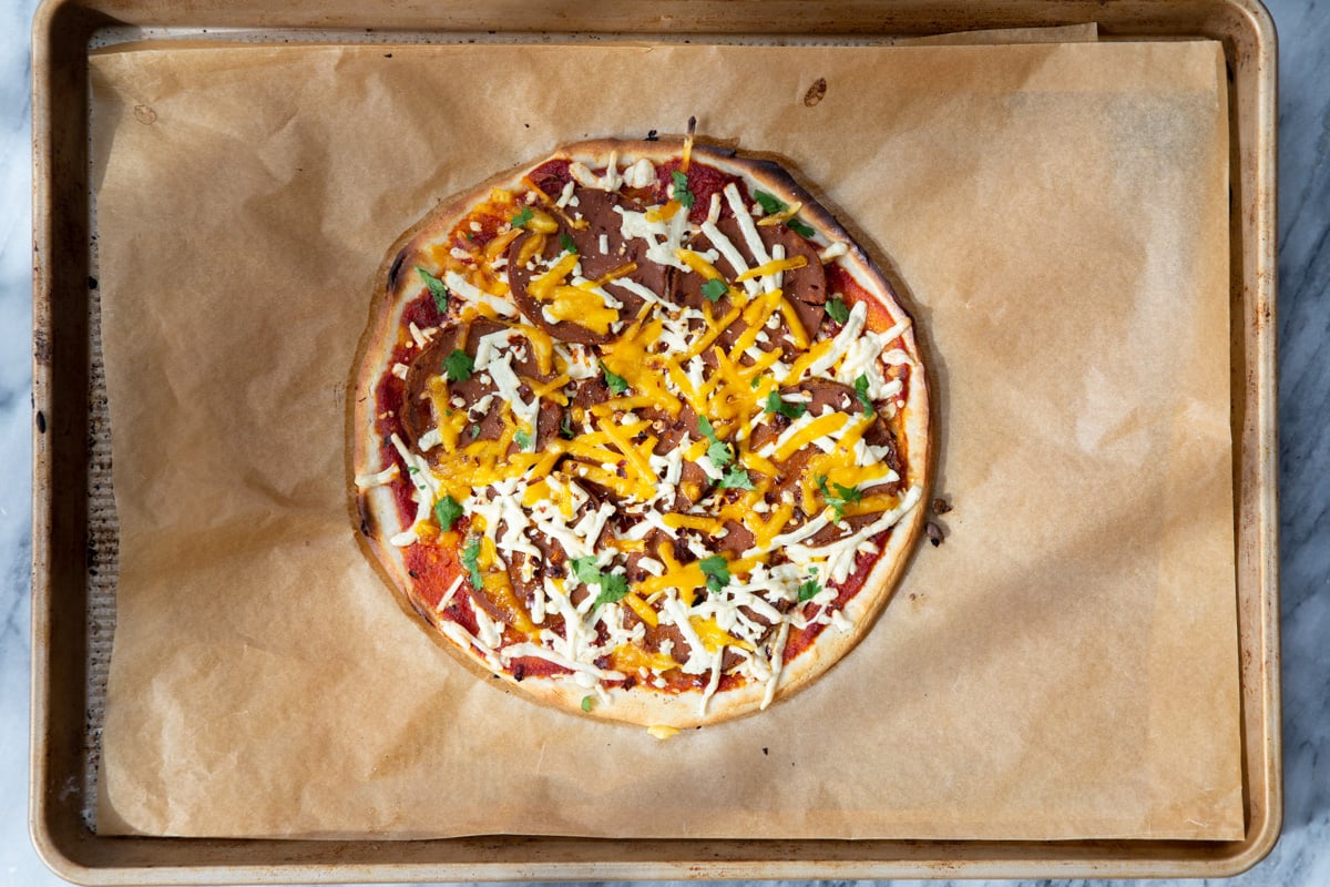 freshly baked vegan almond flour pizza with cheese and pepperoni