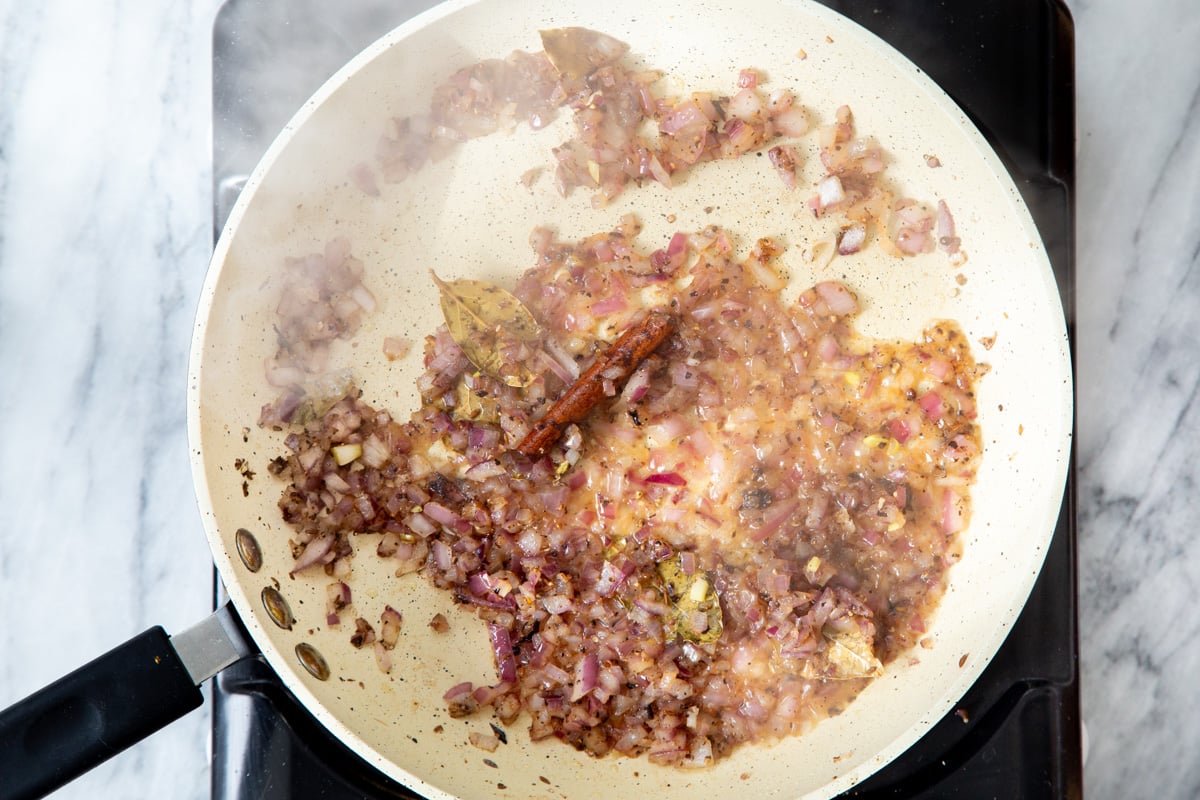 sauteed onion and whole Indian spices in a sauteeing pan