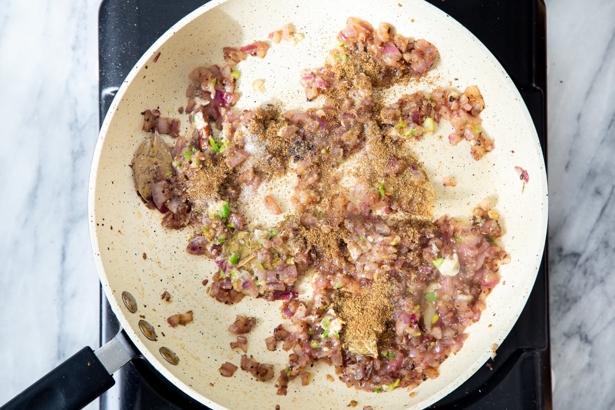 ground spices being added to tempering
