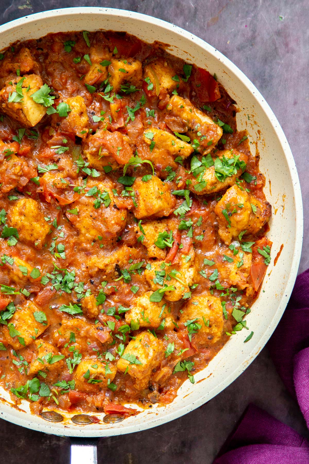 a pan with vegan Khada Masala Murg Curry with Baked Tofu sprinkled with chopped cilantro