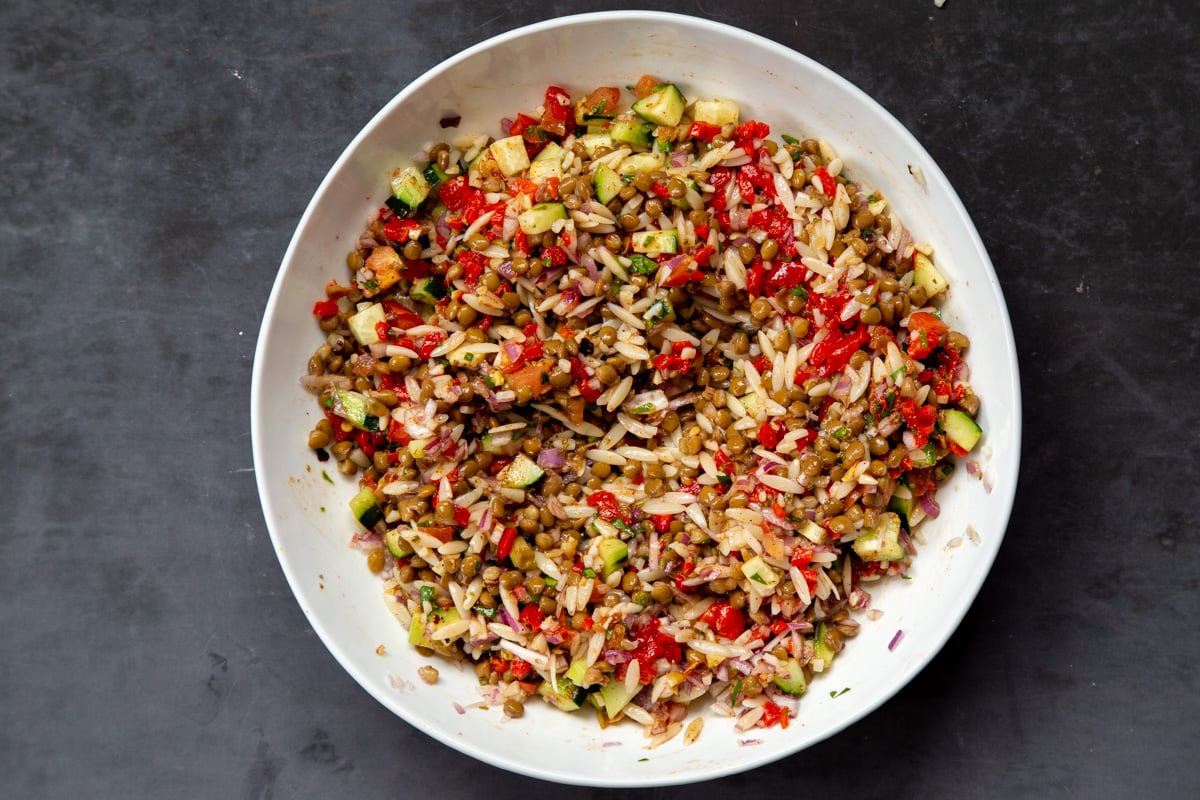 tossed lentil farrot salad with veggies in a white bowl