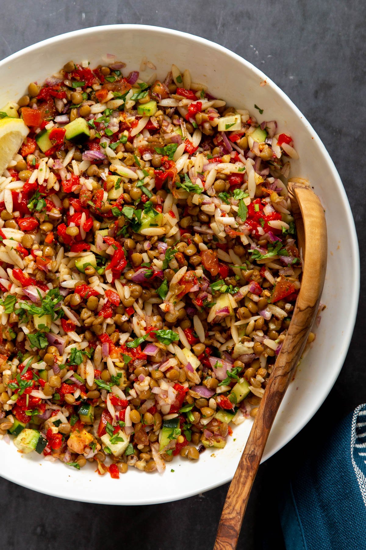 a bowl with vegan lentil farro salad with chopped veggies tossed in lemon vinaigrette