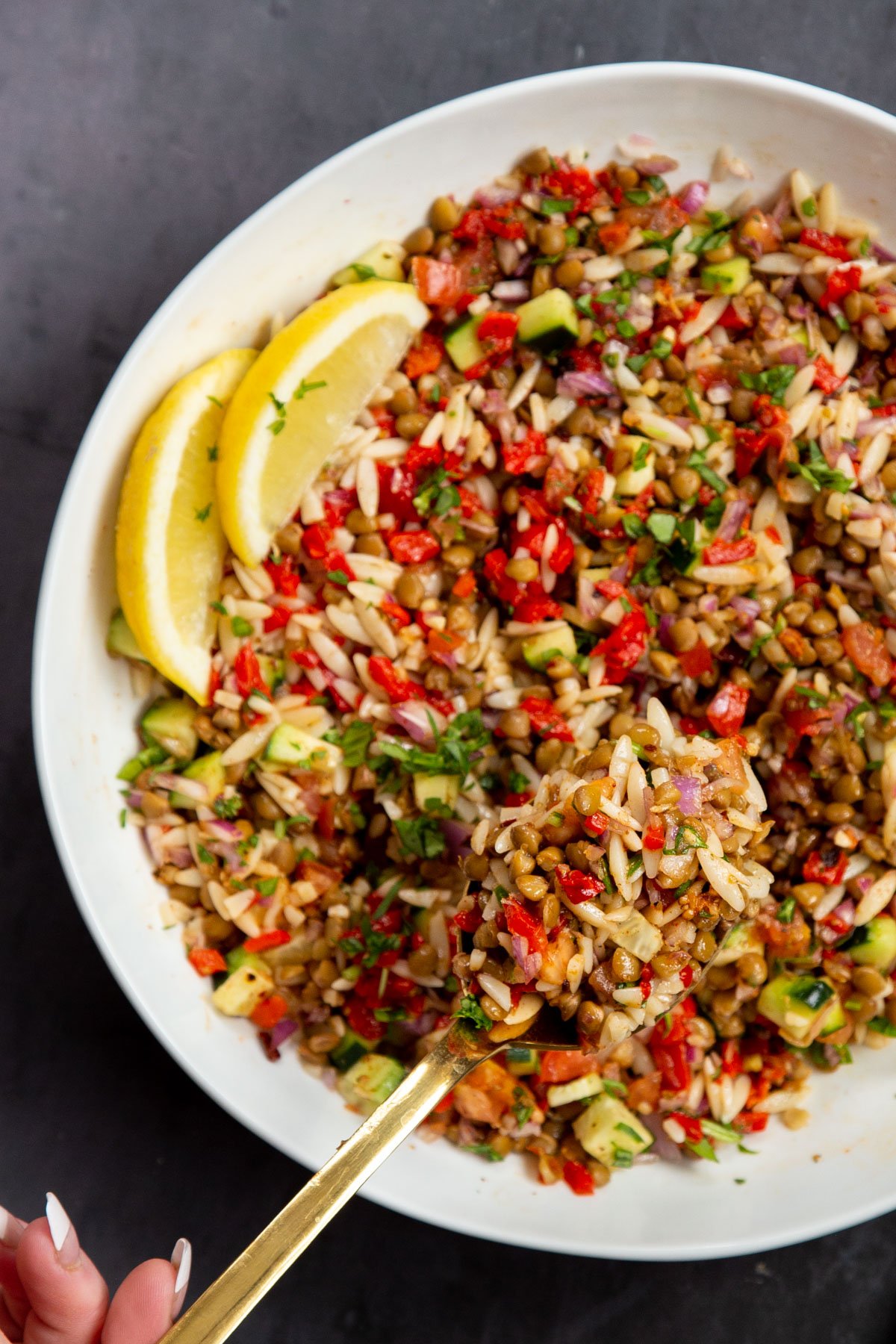 a bowl of lentil farro salad served with lemon wedges