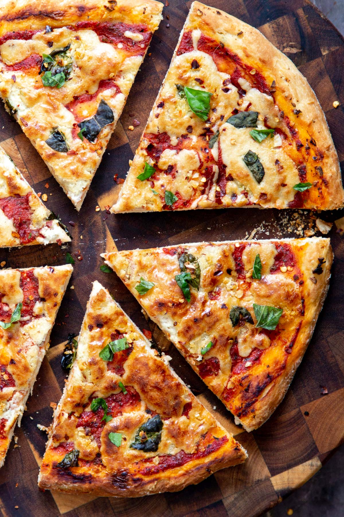 a sliced vegan mozzarella pizza on a wooden board