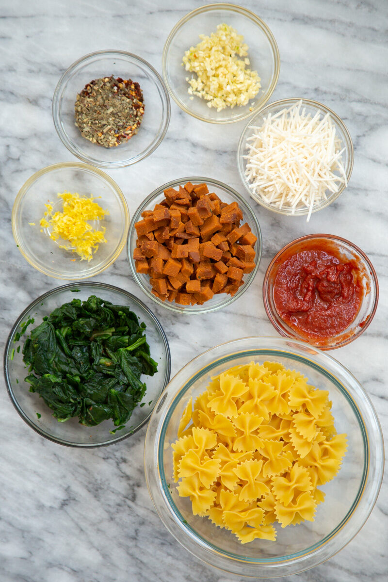 ingredients needed for making vegan pepperoni pasta on a marble countertop