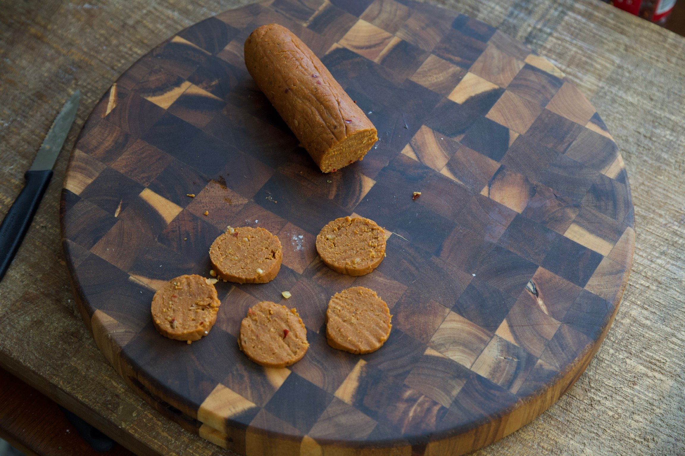 Stove top vegan pepperoni sliced on a cutting board