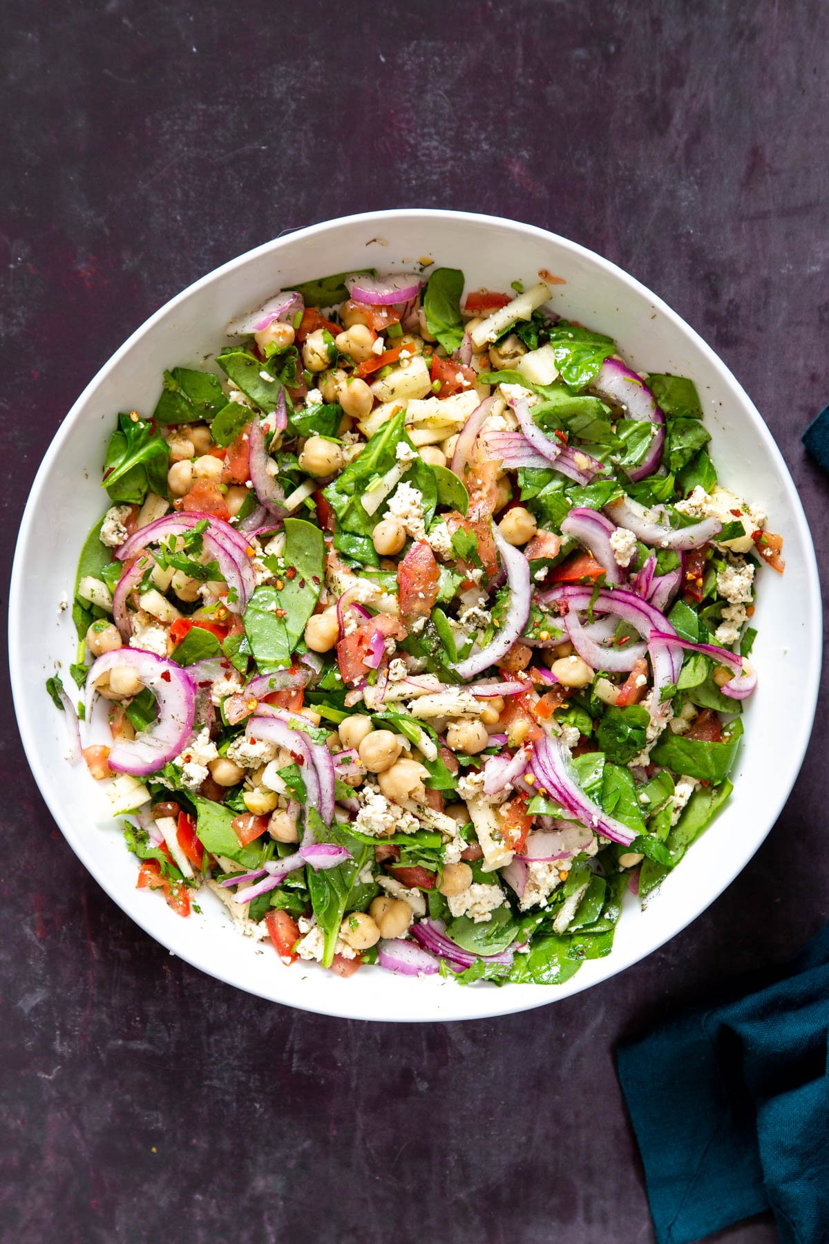 a white bowl with vegan chickpea salad drizzled with lemon dill dressing