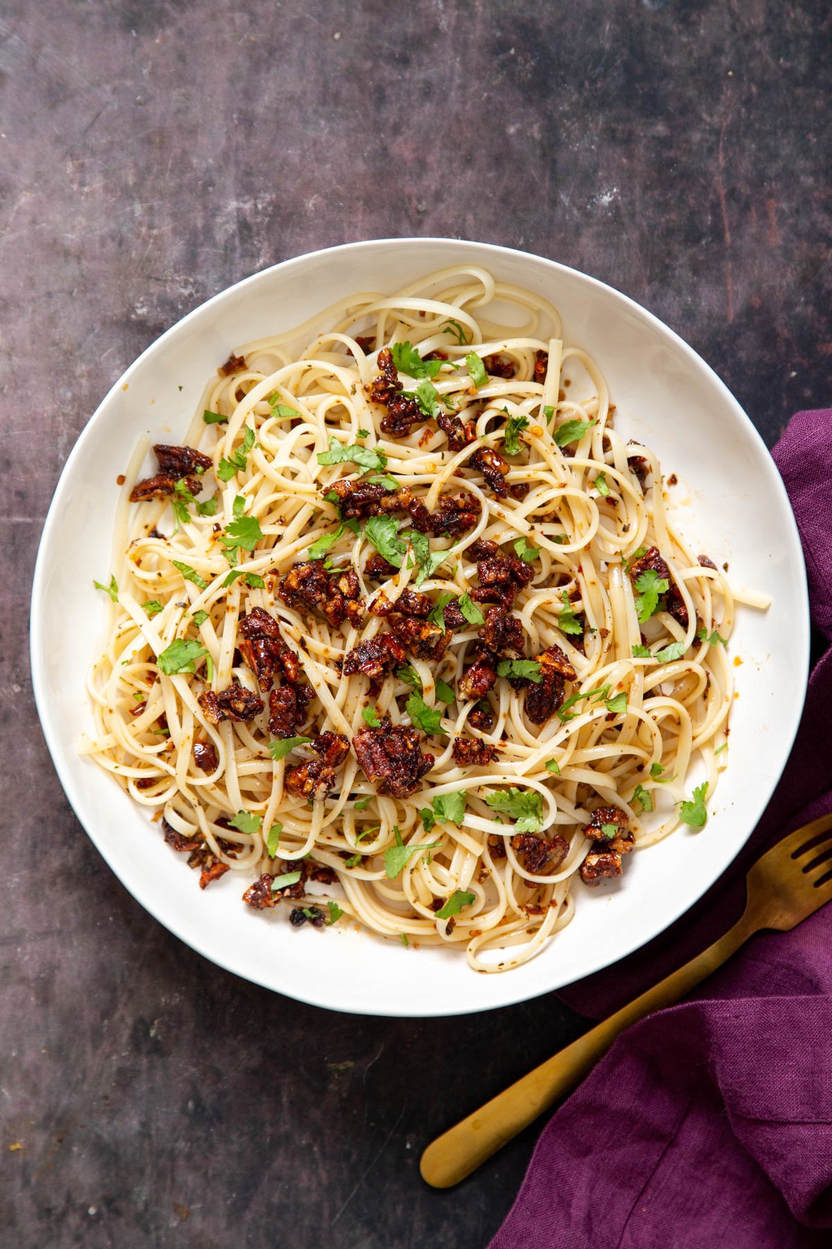 vegan chili garlic oil pasta sprinkled with pecans and chopped cilantro