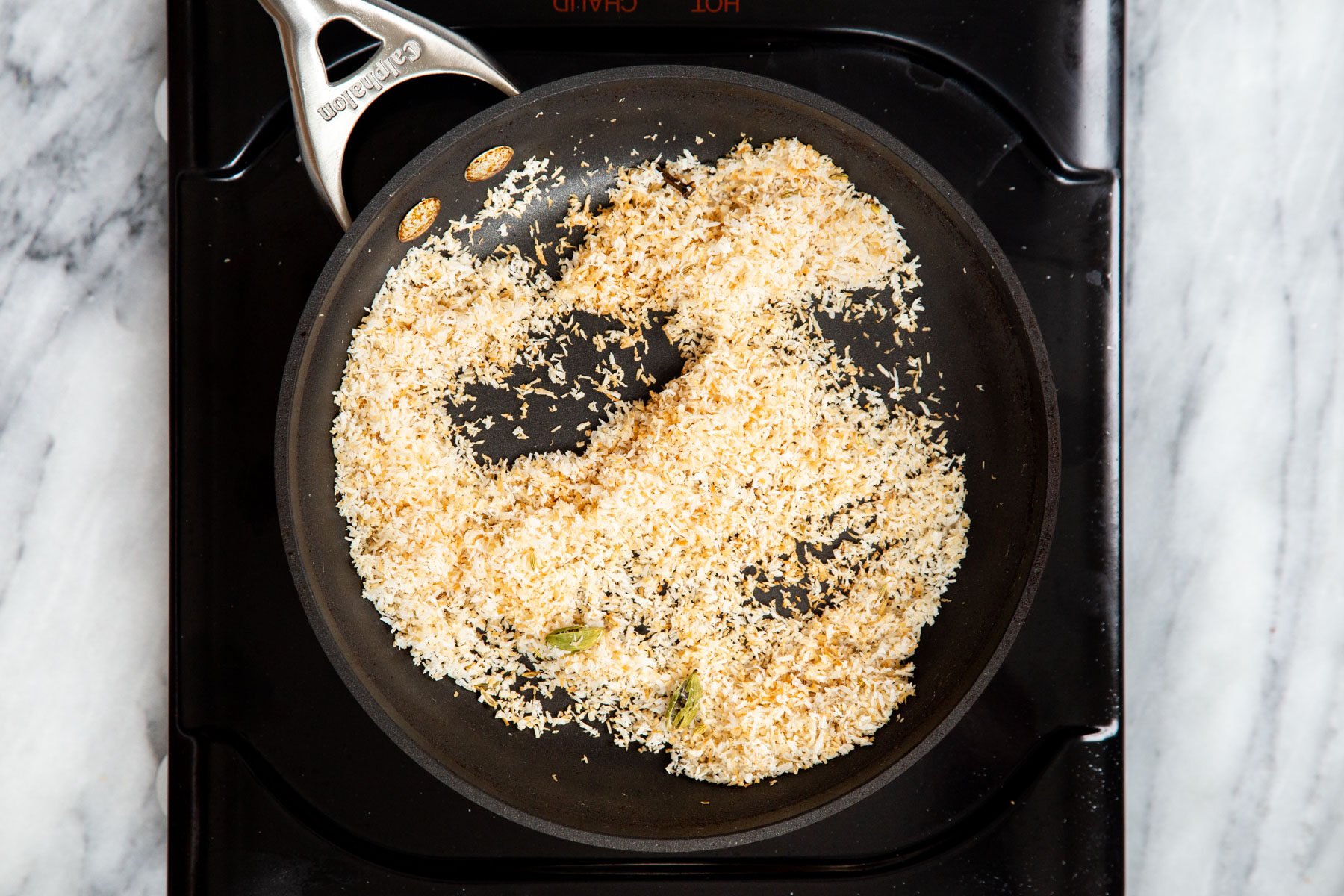 toasted coconut in a sauteeing pan