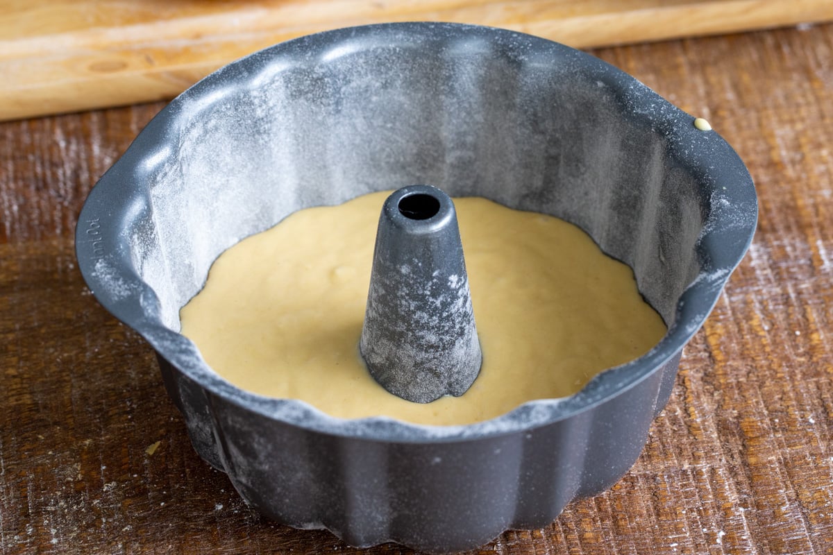 vegan mango cake batter being filled into springform pan