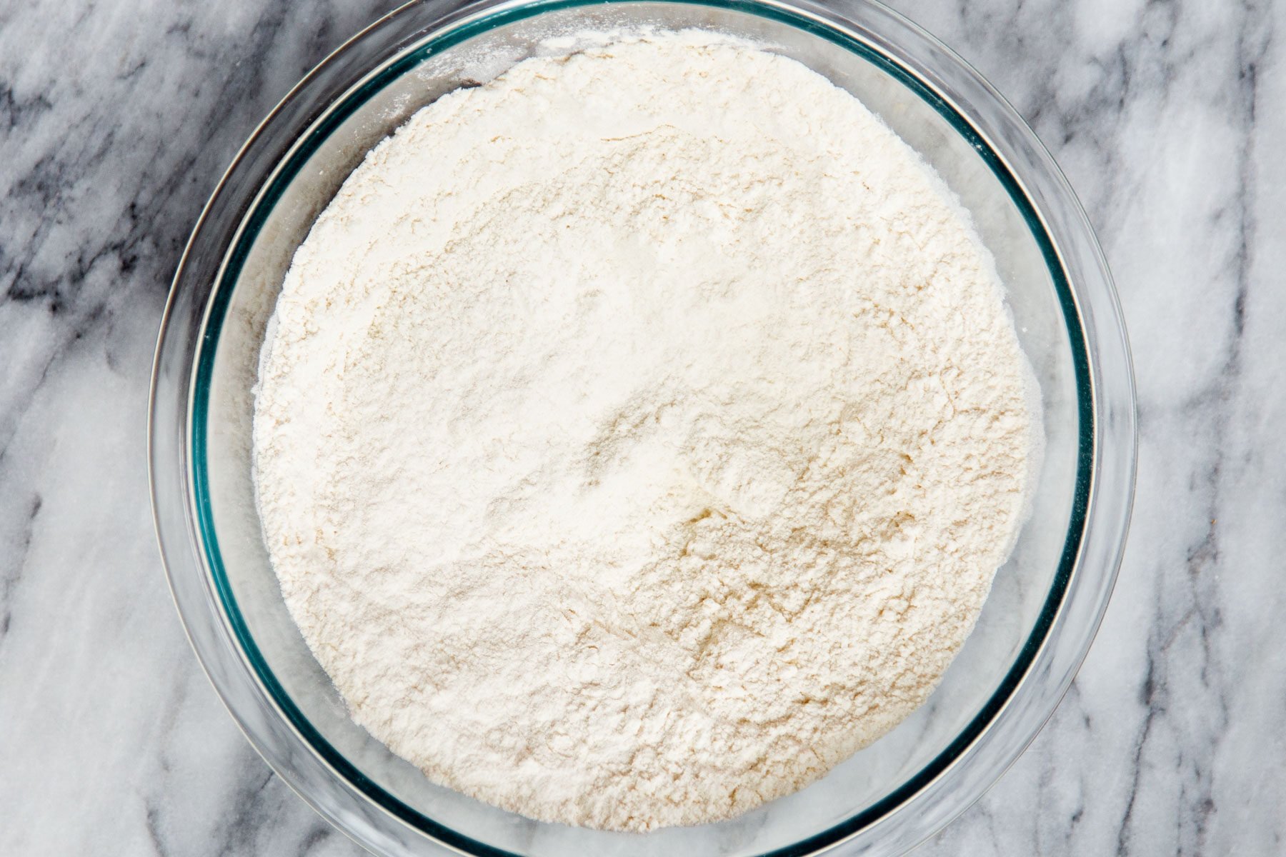 mixed dry cake batter ingredients in a glass bowl