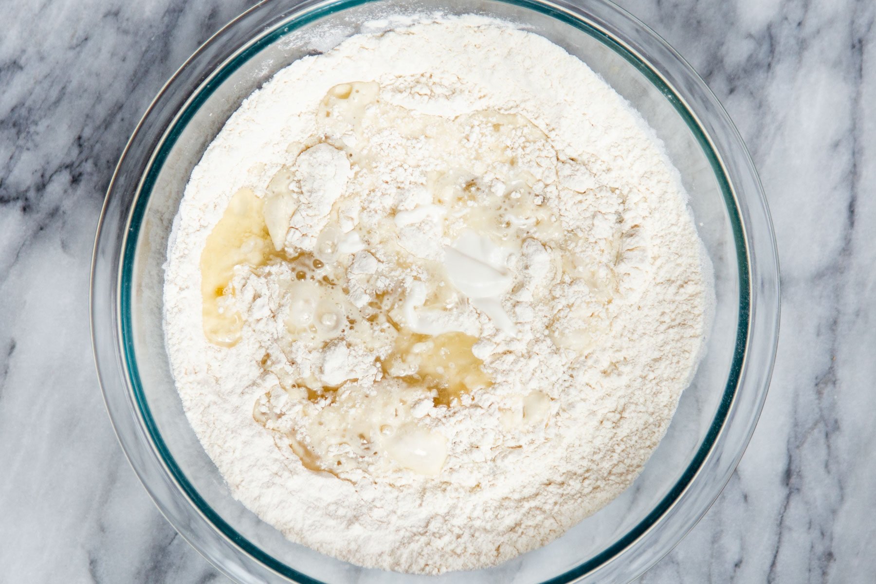 dry cake batter ingredients being mixed with wet ingredients to make cake batter