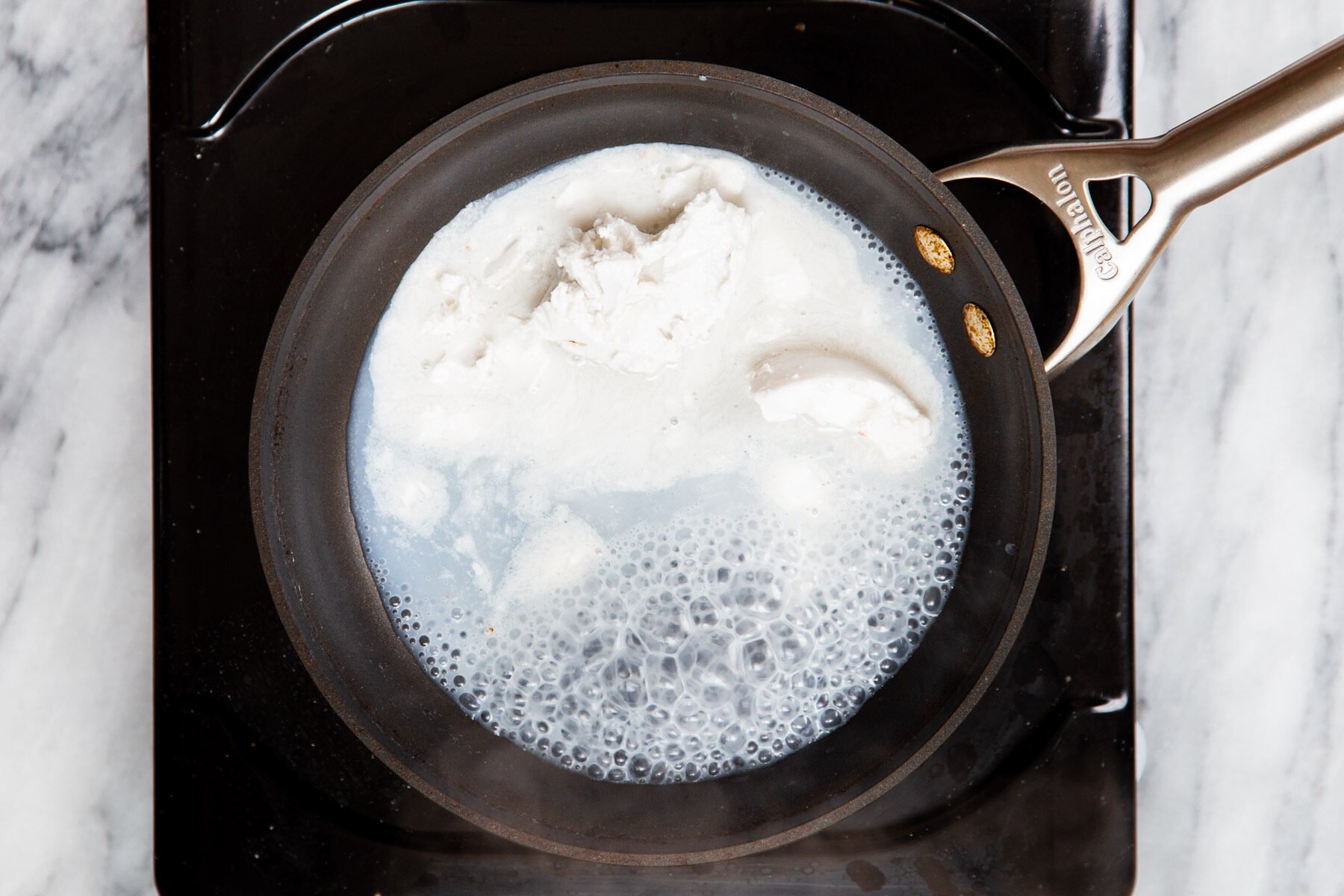 coconut milk being heated in pan to make ganache