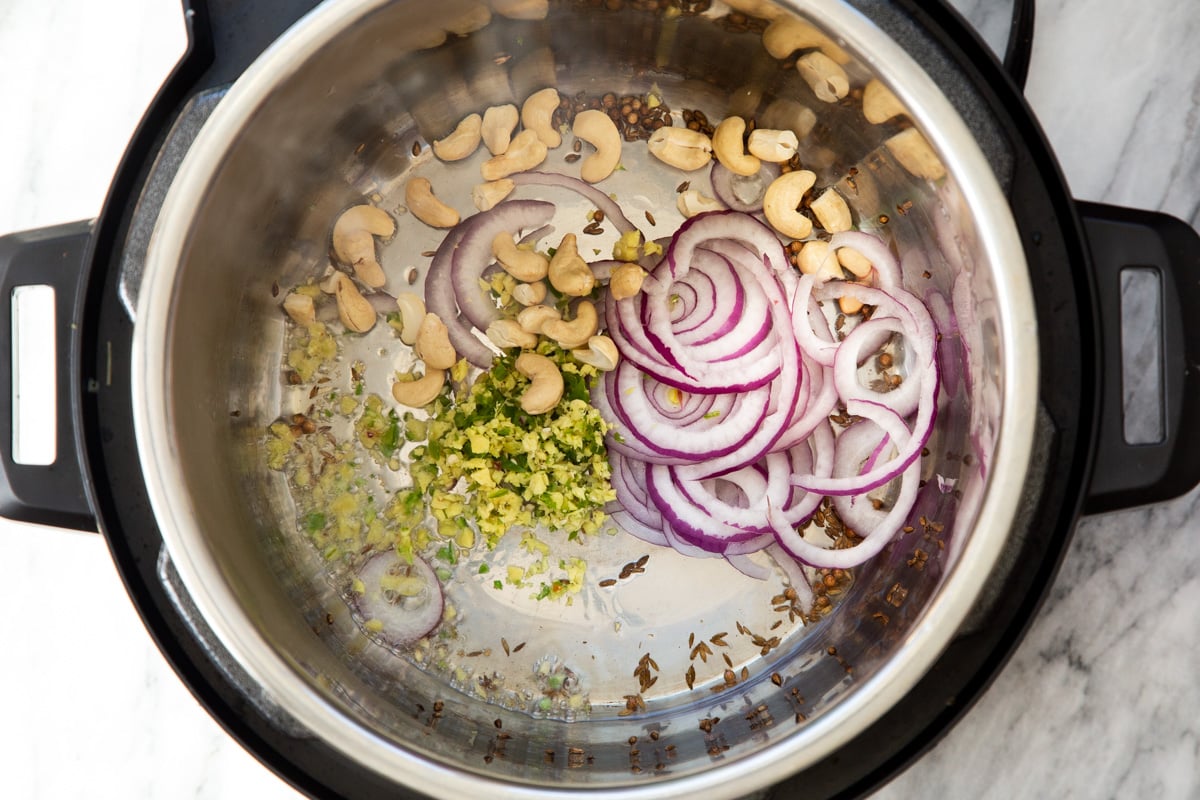 onions, ginger, garlic, cashews and spices sauteeing in an instant pot