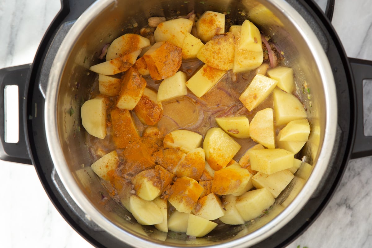 an Instant pot with potatoes and spices for making samosa filling