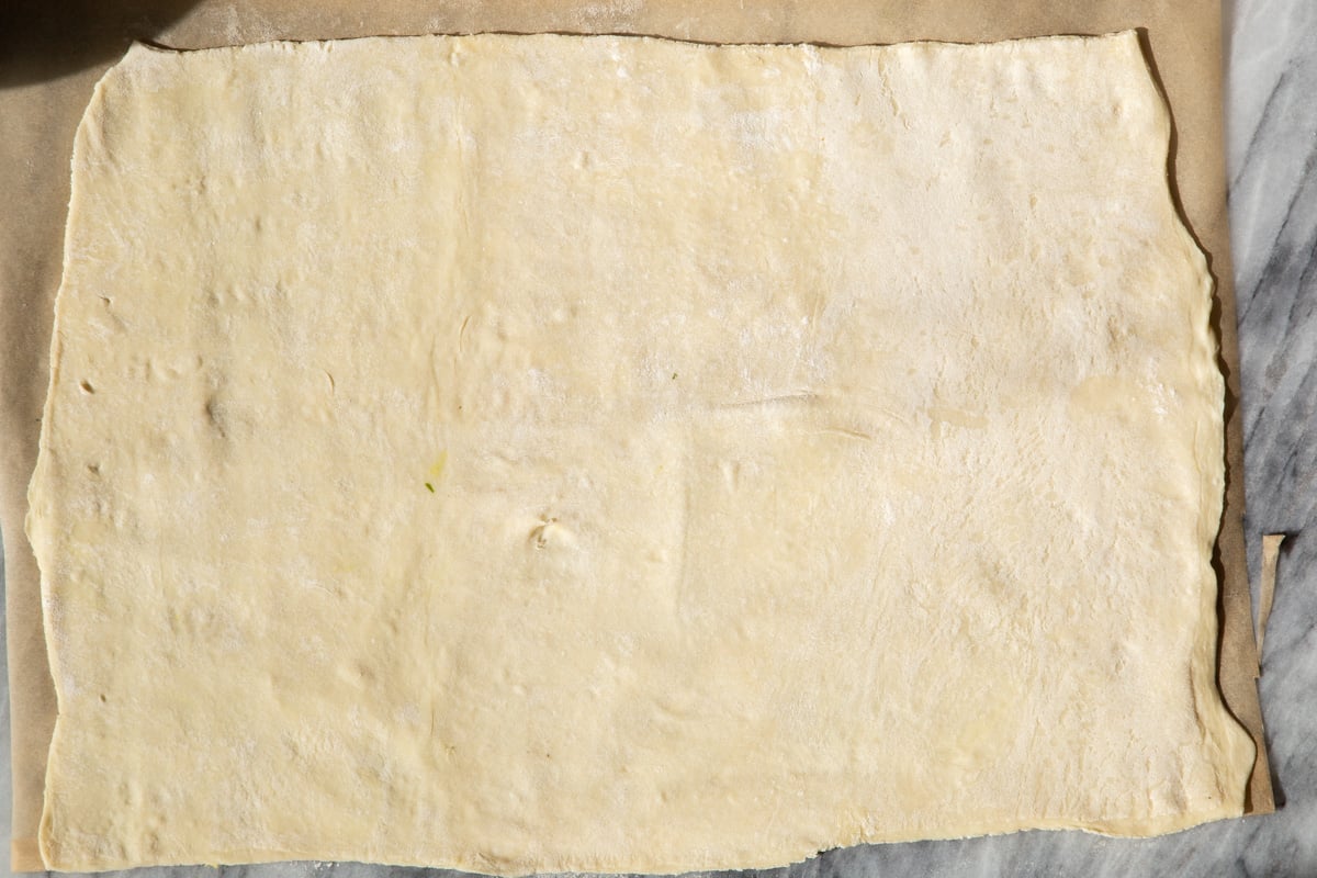 a thawed sheet of puff pastry on a marble counter