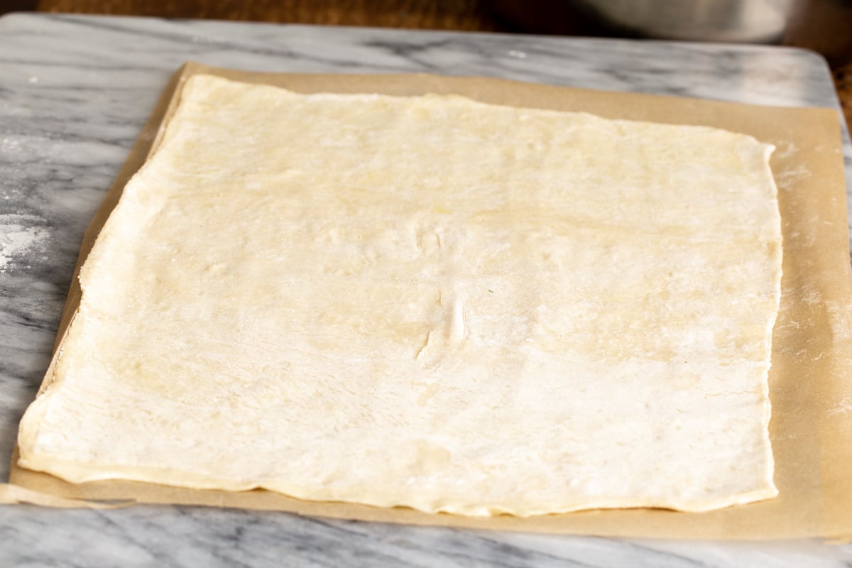 rolled out thawed puff pastry on a sheet of baking paper