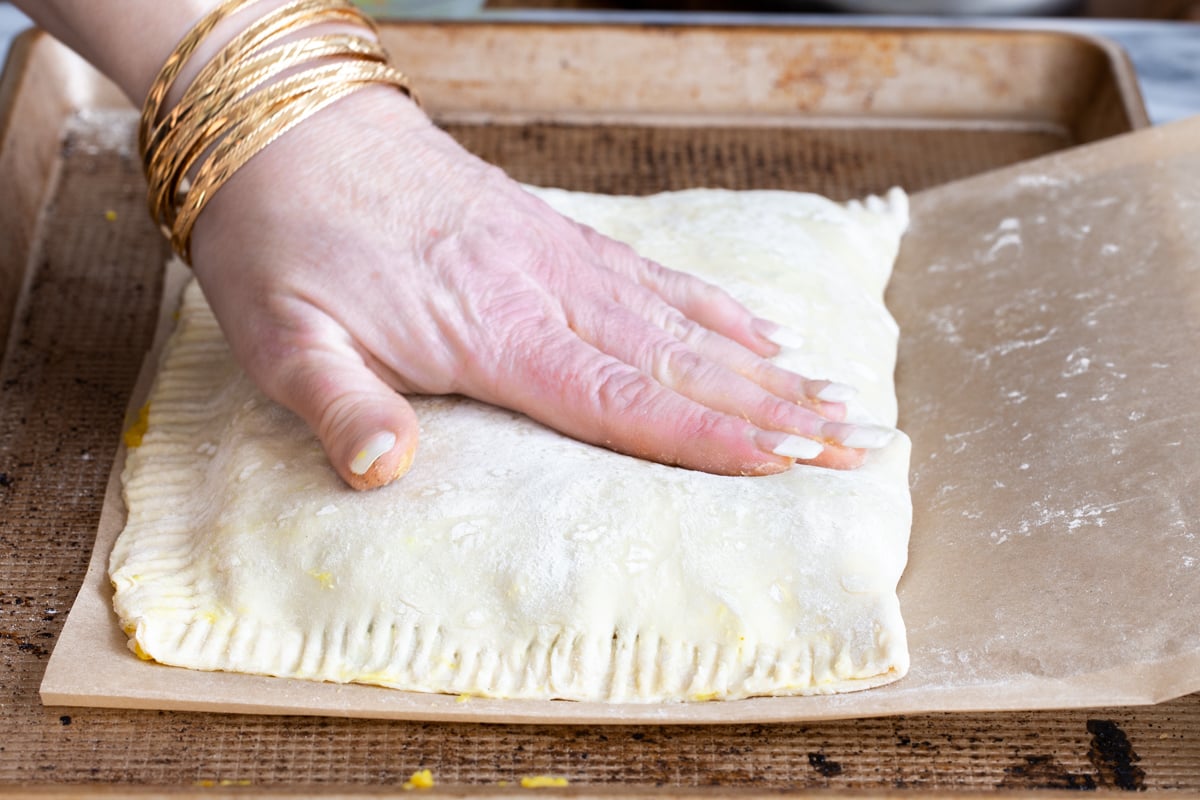 vegan samosa pie being assembled in a baking sheet