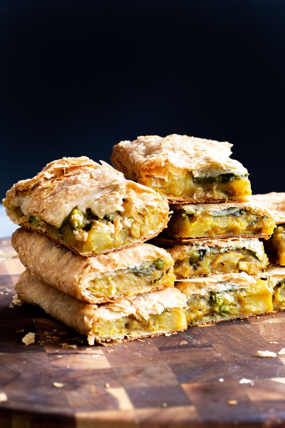 vegan samosa pie cut into pieces on a wooden board