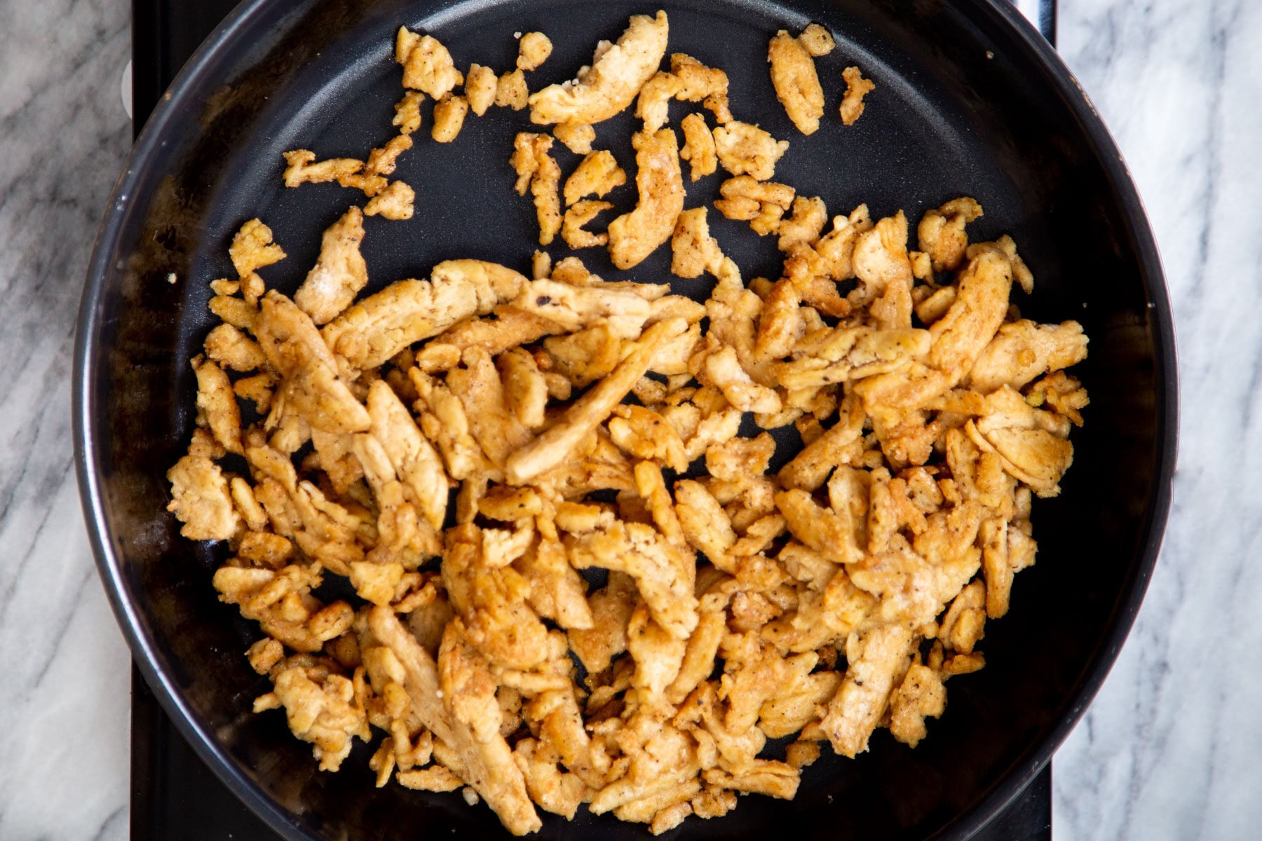 fried soy curls being fried in a skillet