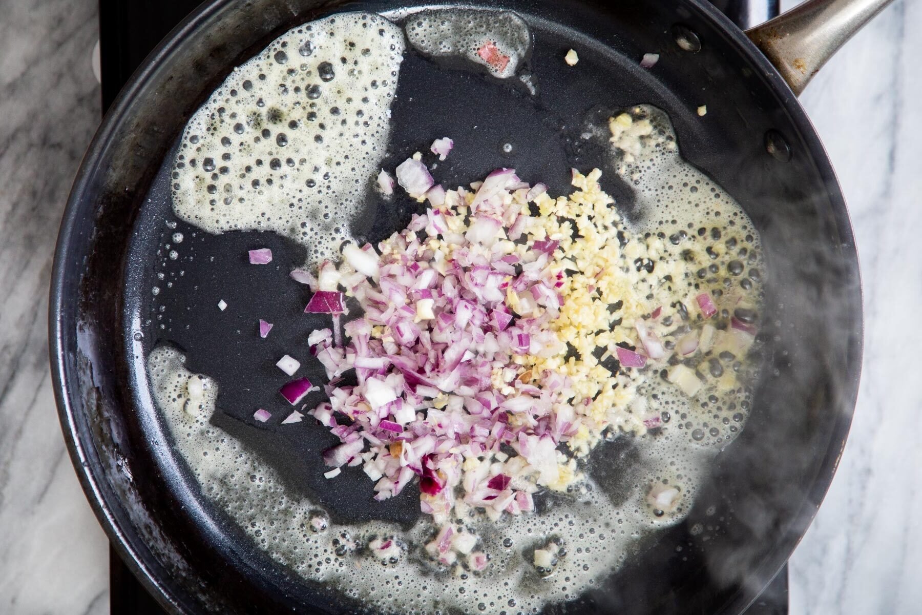 minced almond and garlic being sauteed in vegan butter