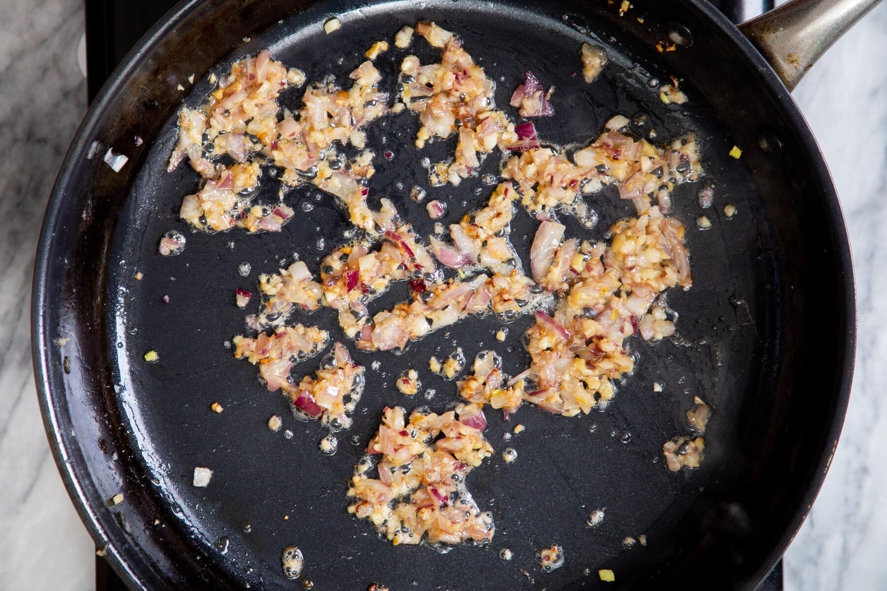 golden fried onion and garlic in a black skillet