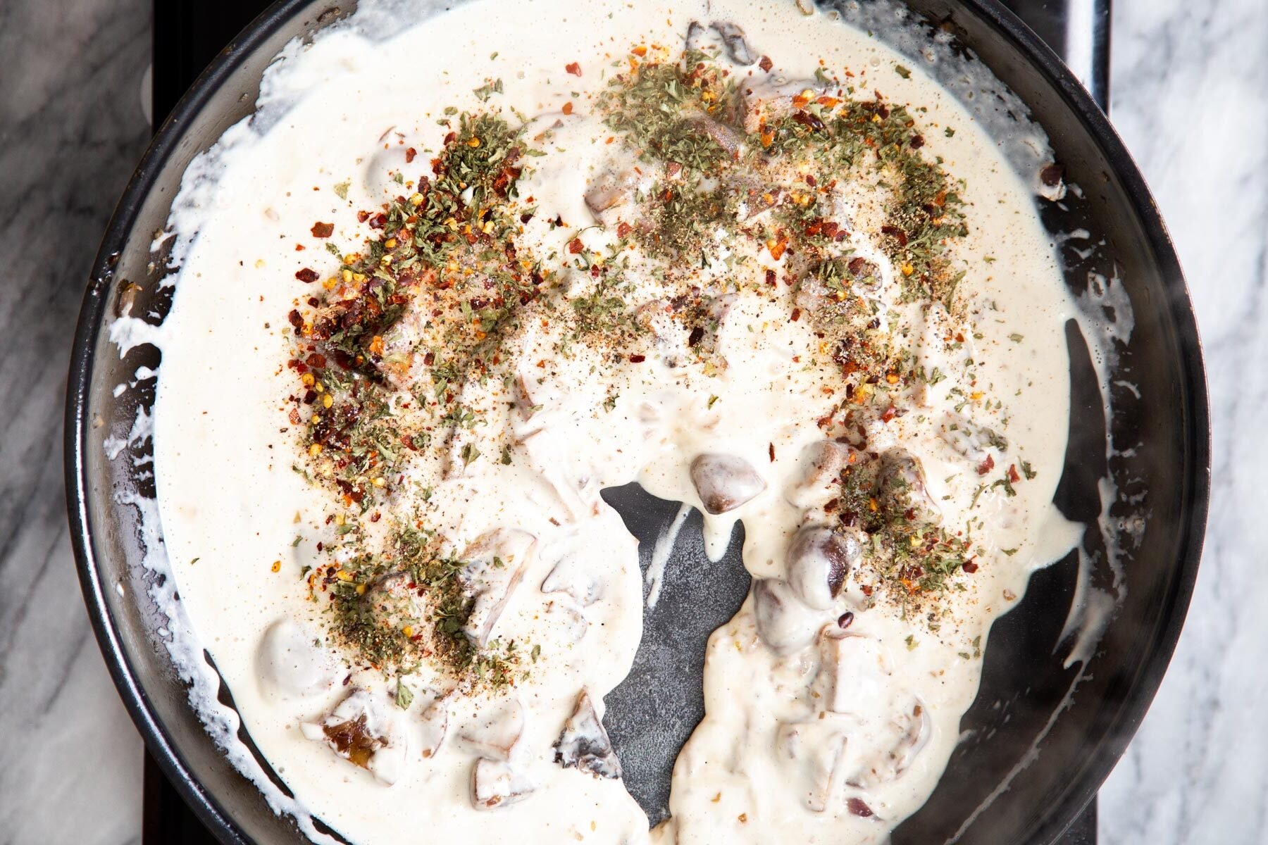 cashew cream being added to mushrooms to make florentine sauce