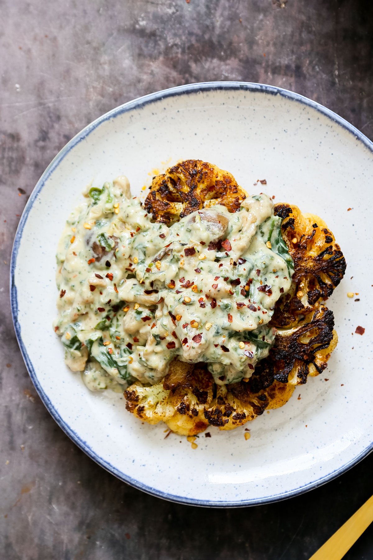 overhead shot of a cauliflower steak topped with soycurl florentine