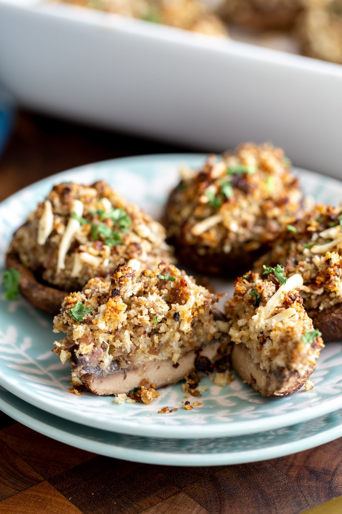 stuffed vegan mushrooms with breadcrumb and cheese filling on two stacked plates