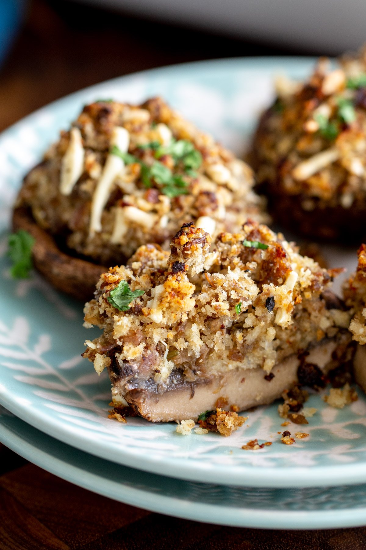 vegan stuffed mushrooms with breadcrumb topping on two stacked plates