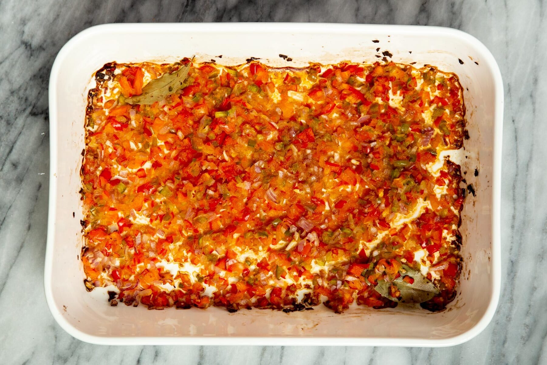 baked chopped bell pepper and onions in a white casserole dish