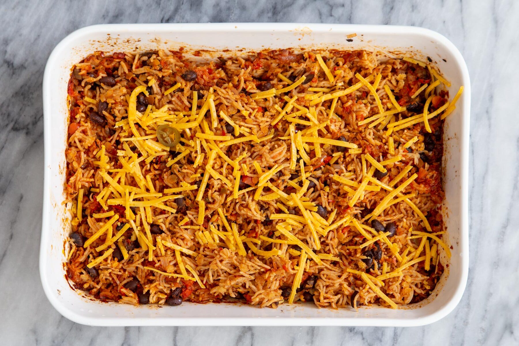 Tex Mex Rice Casserole sprinkled with vegan cheese