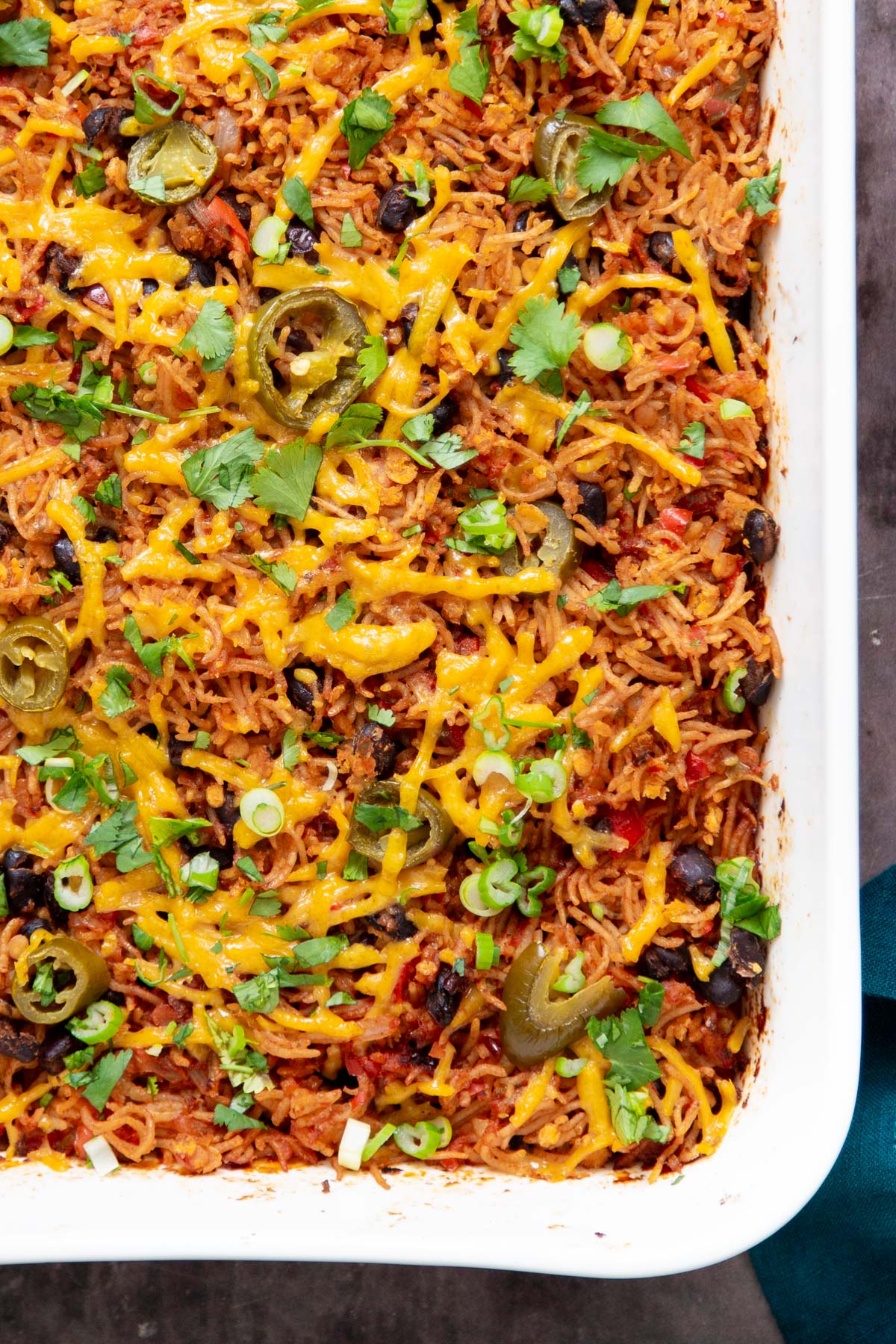 vegan tex mex rice casserole in a white casserole dish sprinkled with cilantro
