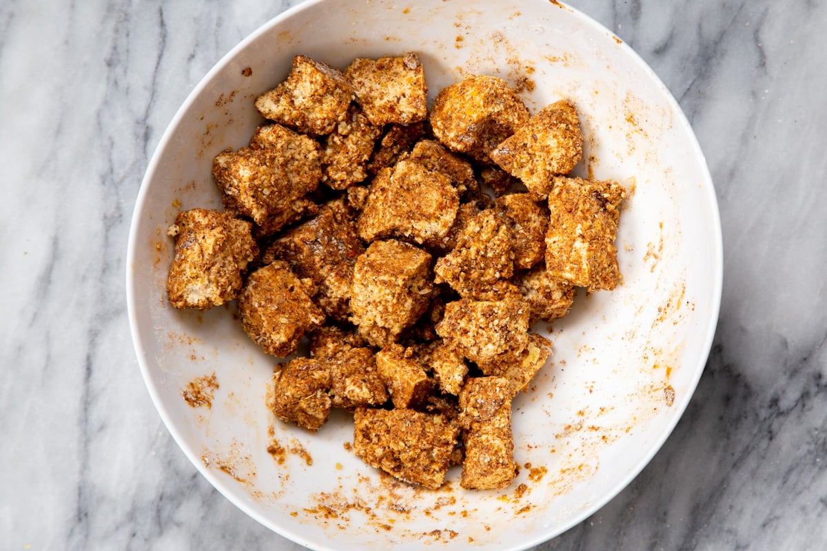 marinated tofu chunks in a white bowl