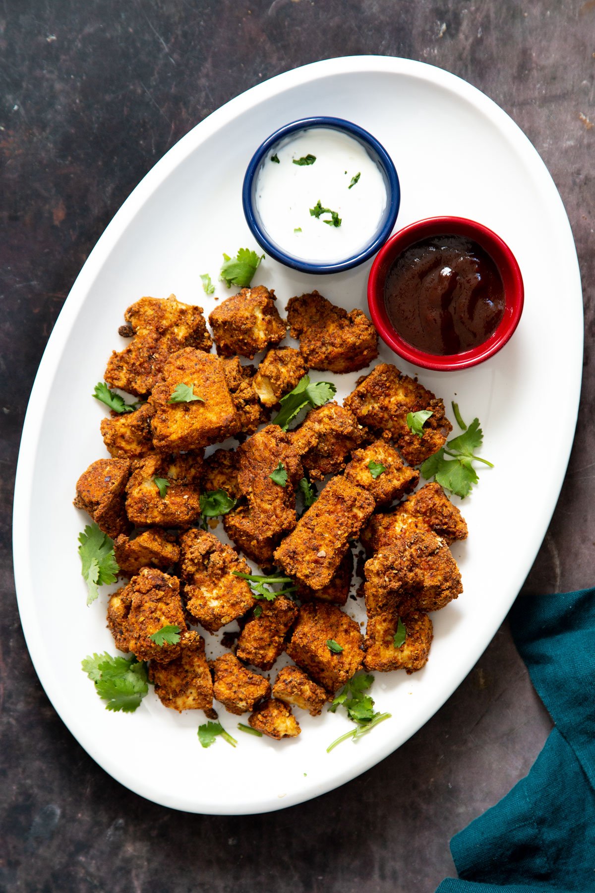 a plate with vegan baked tofu nuggets with ranch and bbq dip