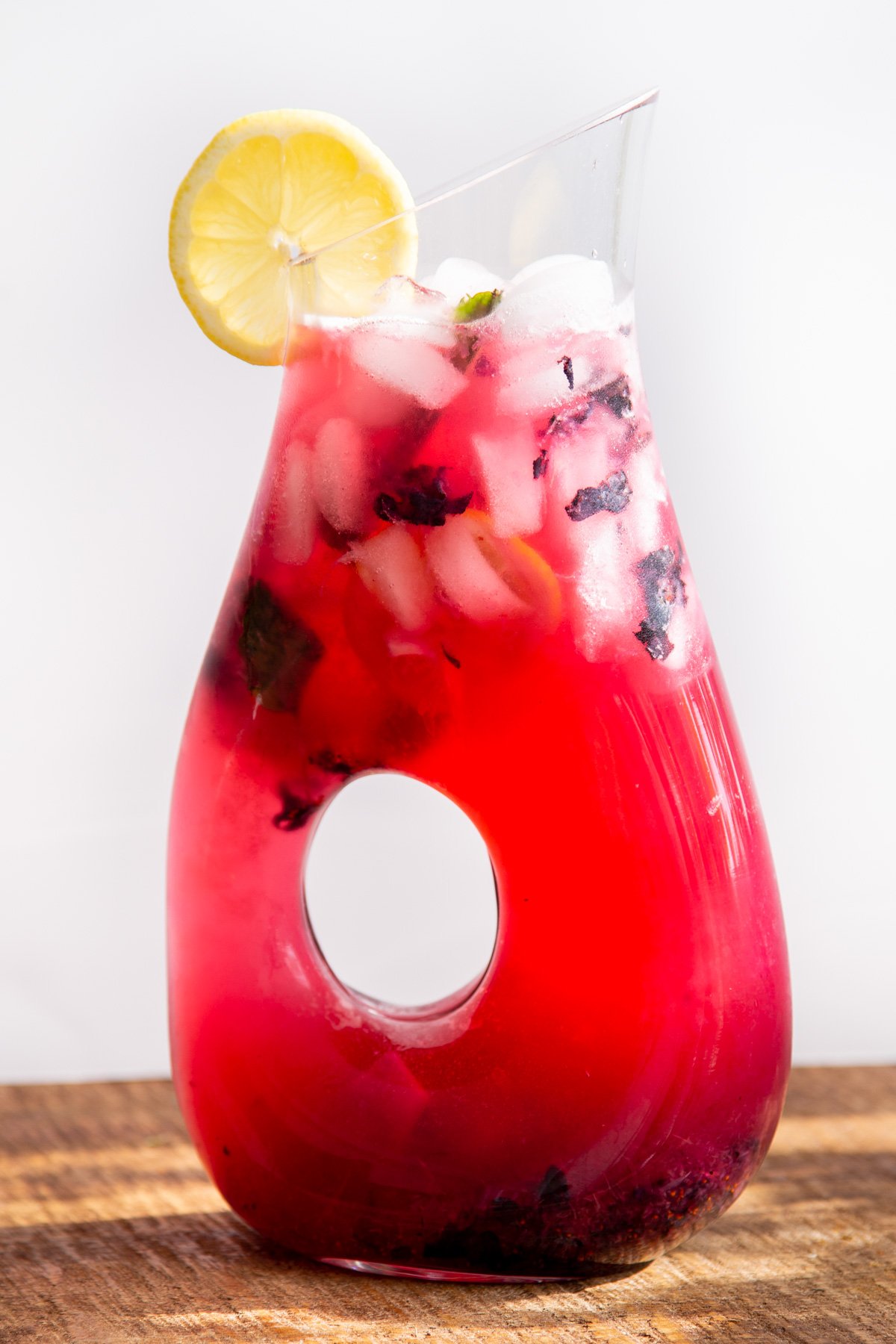 a glass jar of homemade fresh blueberry lemonade with ice cubes and mint leaves