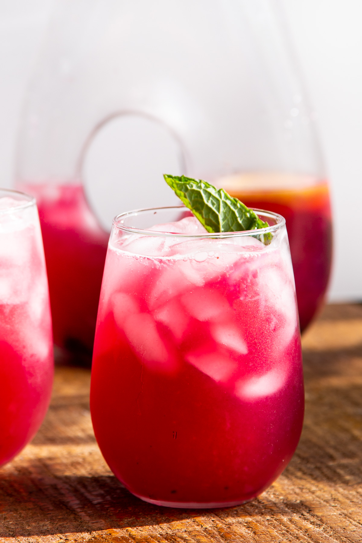 a glass of homemade blueberry lemonade served with a mint leaf